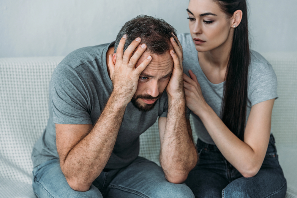 A woman comforts her spouse who is suffering from depression