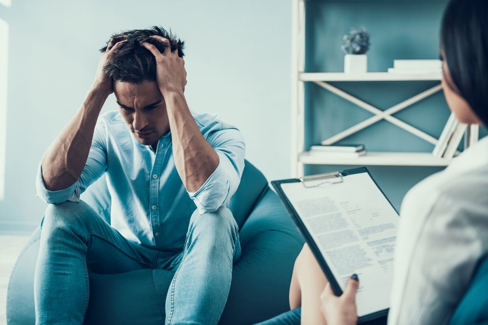 trauma-blocking a man showing signs he's suffering from mental health and talking to a therapist