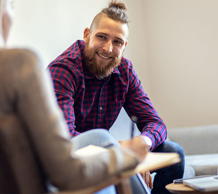 man smiling sitting down in therapy