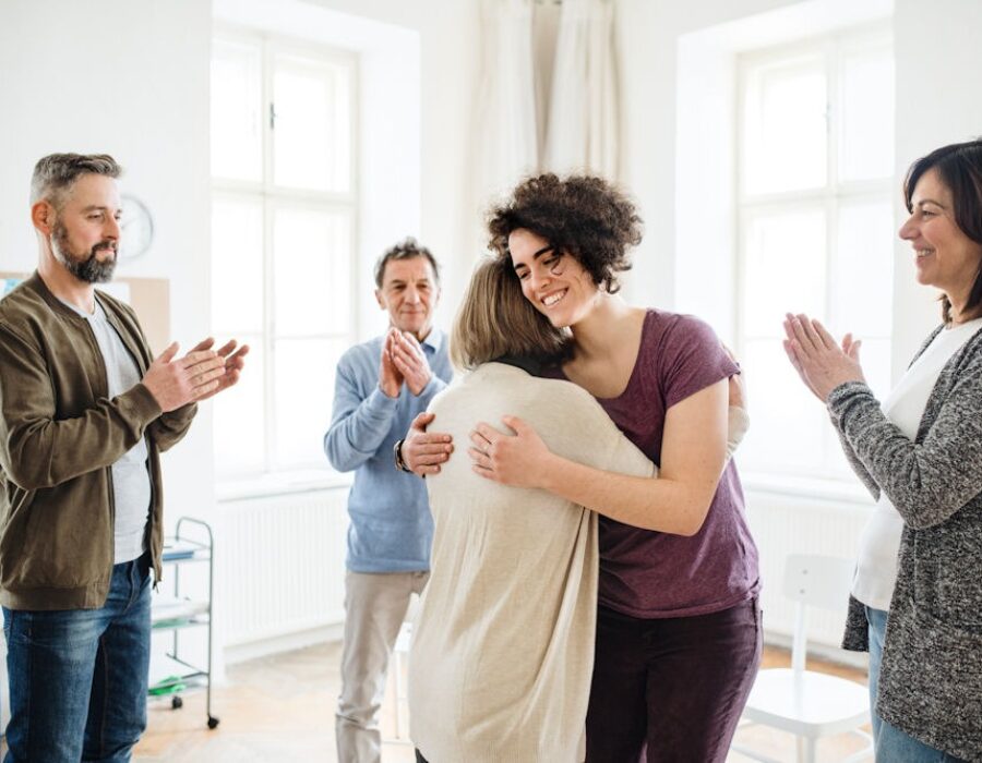 a group of people clapping while standing in circle