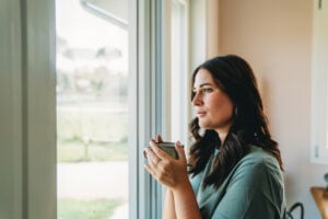 Woman looking out a window reflecting on attachment styles, emotional healing, and relationships