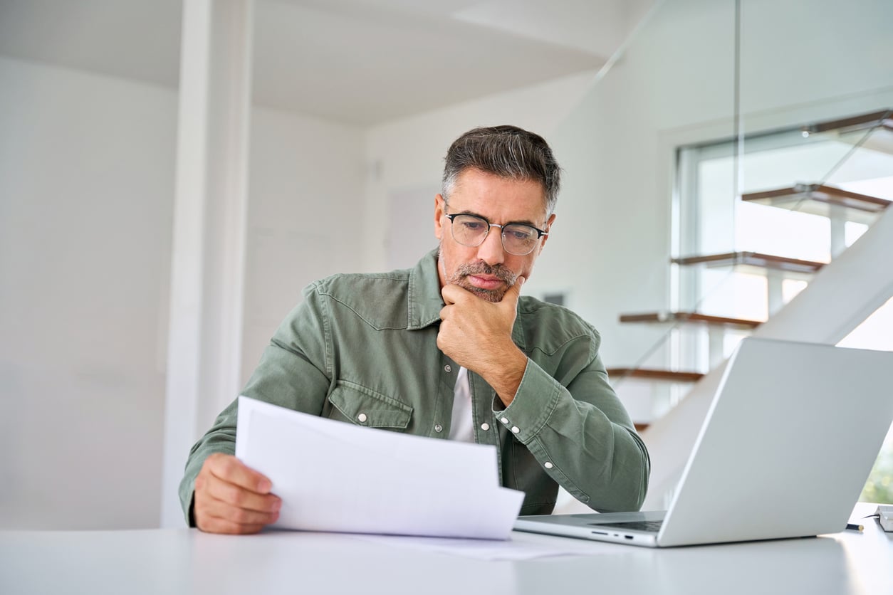 Man reviewing health insurance paperwork for mental health treatment coverage.
