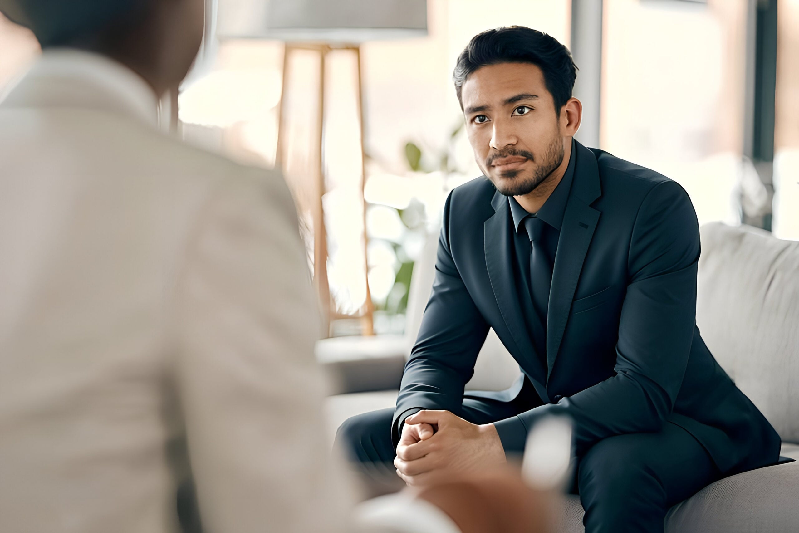 Working professional speaking privately with a therapist during confidential residential trauma treatment.